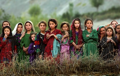  Girls watch U.N. workers unloading election packages from a U.N. helicopter in the village of Ghumaipayan Mahnow, about 410 kilometers northeast of Kabul, Afghanistan, on October 4, 2004.        