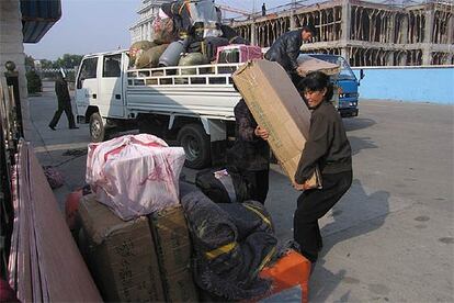 Un grupo de  norcoreanos descarga un camión con muebles y electrodomésticos de segunda mano en el paso fronterizo de Tumen.