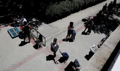 Colas de personas esperan a las puertas de la Parroquia Santa María Micaela de Madrid para recibir ayuda alimentaria.