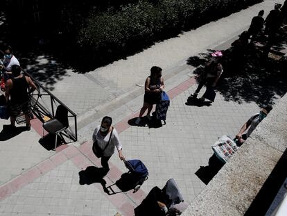 Colas de personas esperan a las puertas de la Parroquia Santa María Micaela de Madrid para recibir ayuda alimentaria.