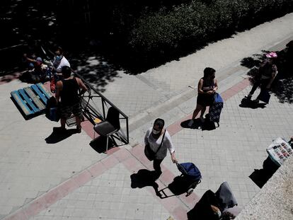 Colas de personas esperan a las puertas de la Parroquia Santa María Micaela para recibir una ayuda alimentaria durante el día en el que el Gobierno aprobó el ingreso mínimo vital.