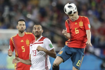 Iniesta heads the ball as Boutaib and Busquets look on.