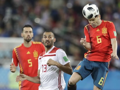 Iniesta heads the ball as Boutaib and Busquets look on.