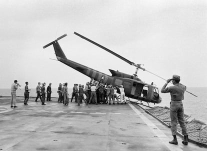 Personal de la Marina estadounidense empuja un helicóptero al mar con el fin de hacer espacio para recibir más vuelos en un portaviones, el 29 de abril de 1975.