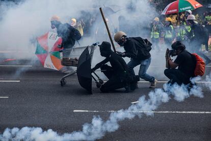 Los manifestantes reaccionan entre los gases lacrimógenos disparados por la policía en el distrito de Sha Tin, de Hong Kong, durante los disturbios en protesta por la conmemoración en el territorio autónomo de los 70 años del régimen comunista chino.