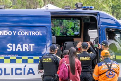 La Policía, bomberos y familiares revisan las pantallas que proyectan el vídeo en tiempo real de los drones que usaron como ayuda para localizar a los jóvenes perdidos en los cerros de Monserrate.