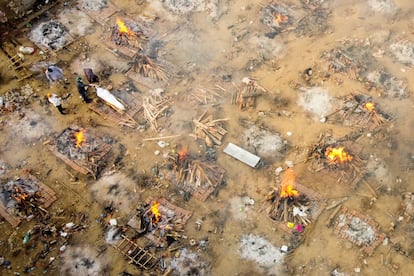 Foto aérea del 26 de abril que muestra cómo familias y amigos se despiden de una víctima de covid en un crematorio de Nueva Delhi.