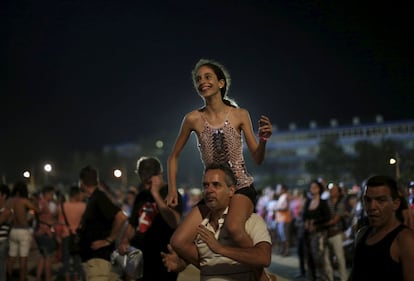 Un hombre carga en hombros a una niña para que pueda mirar mejor la presentación de la banda The Rolling Stones en La Habana, este viernes 25 de marzo.