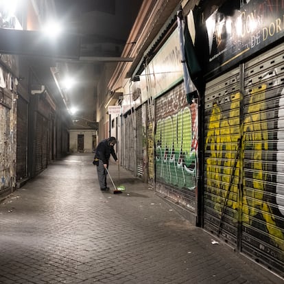 El frutero Jose María, limpiando la calle antes de abrir su frutería en el mercado de Antón Martín.