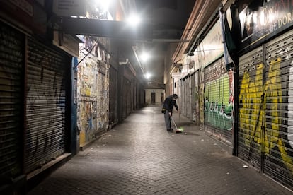 El frutero Jose María, limpiando la calle antes de abrir su frutería en el mercado de Antón Martín.