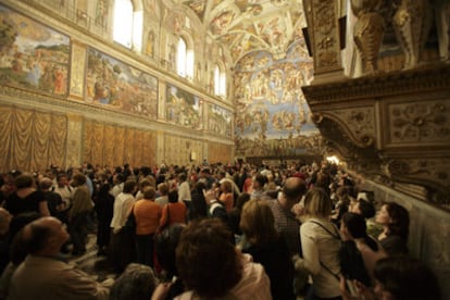 Visitantes de la Capilla Sixtina contemplan los frescos de Botticelli, Ghirlangaio y Rosselli (de izquierda a derecha), bajo la cúpula y el frontispicio de Miguel Ángel.