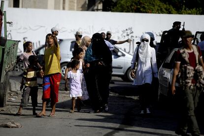 Mujeres, niños y rebeldes se juntan en una calle de Trípoli después de que los insurgentes cercaran la ciudad y rodearan al líder del país, Muamar el Gadafi.