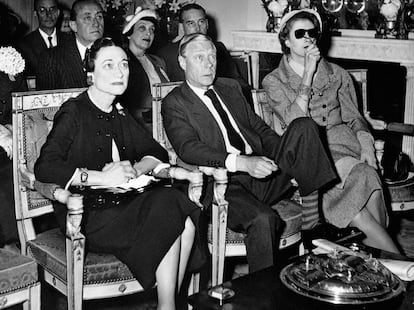 The Duke and Duchess of Windsor (Edward and Wallis Simpson) watch the coronation of Queen Elizabeth II on the television screen at the Paris home of Mrs. Margaret Biddle (right), the American millionairess. Prince Edward renounced the throne because of their love affair.