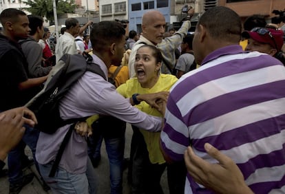 Una partidaria de la oposición (c) discute con un partidario del gobierno de Nicolás Maduro, en Caracas. 