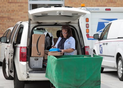 A United States Postal Service (USPS) worker loads mail into a delivery truck at the post office in Royal Oak, Michigan, U.S. August 17, 2020.