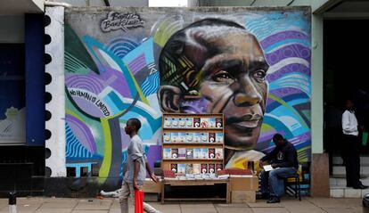 Un hombre pasea junto a un graffiti con el poseedor del récord mundial de maratón de Kenia Eliud Kipchoge en una avenida en el centro de Nairobi, Kenia. 
 