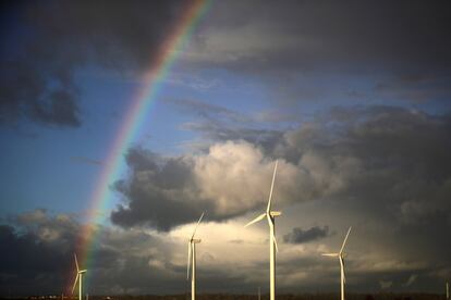 Un arco iris aparece tras las turbinas de viento en los pantanos de la sal de Ince, cerca a las plantas químicas y de fabricación del estuario del río Mersey, en Runcorn (Inglaterra).