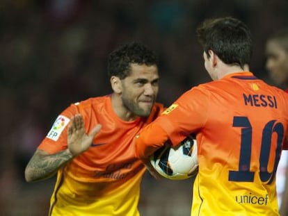Alves felicita a Messi tras un gol.