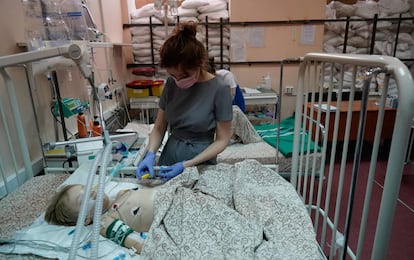 La enfermera Vladislava Filonenko atiende a Belegay, de 5 años, en una habitación protegida por sacos de arena en el Hospital Clínico Infantil Regional de Zaporizhzhia, el martes.
