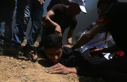 Um palestino ferido cai no chão durante o protesto entre a fronteira de Gaza com Israel.