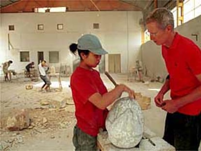 El escultor Uli Schwander conversa con una alumna japonesa en el taller de Cóbdar.
