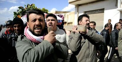 Varios hombres portan un cadáver en Qusayr, cerca de Homs.
