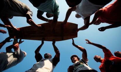 Musulmanes bosnios cargan un ataúd preparado para un entierro conjunto en el cementerio conmemorativo de Potocari (Bosnia), en julio de 2011.