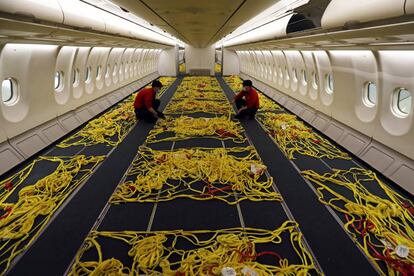Empleados de Iberia adaptan el interior de un avión de pasajeros
para convertirlo en uno de carga en el aeropuerto de Madrid-Barajas durante la pandemia.