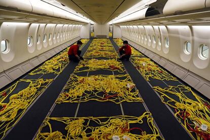 Empleados de Iberia adaptan el interior de un avión de pasajeros
 para convertirlo en uno de carga en el aeropuerto de Madrid-Barajas durante la pandemia.