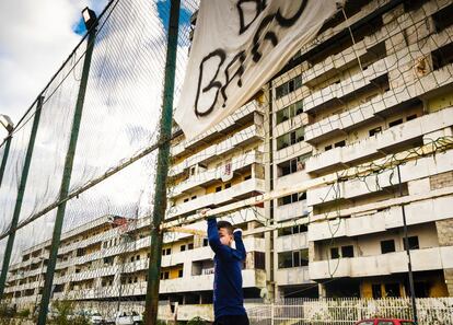 En los setenta se construyeron siete inmensos edificios con forma de vela, cada uno pintado de un color que le daba nombre, para descongestionar otros barrios populares. El barrio de Scampia estaba diseñado para albergar a 80.000 personas. Llegaron a vivir 100.000. La Camorra se puso al mando. En la imagen, un niño del barrio juega en el campo de fútbol en mitad de Las Velas.