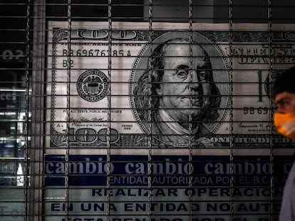 Una persona camina frente a una casa de cambio, en Buenos Aires (Argentina).