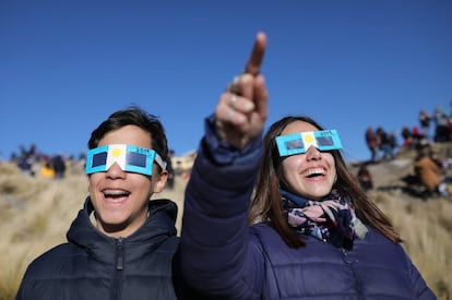 Dos niños con anteojos protectores miran el Sol antes del eclipse solar total de este martes, en Merlo, San Luis (Argentina).