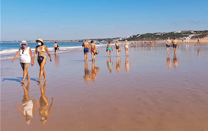 Paseos con mascarilla por la playa con marea baja el El Puerto de Santa María (Cádiz). / Luis Polo