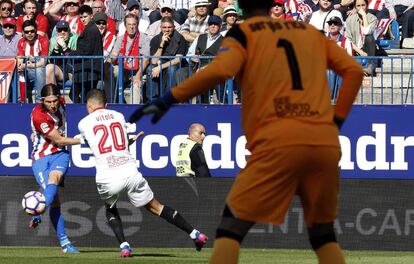 El defensa brasileño del Atlético de Madrid Filipe Luis disputa un balón con el jugador del Sevilla Vitolo.