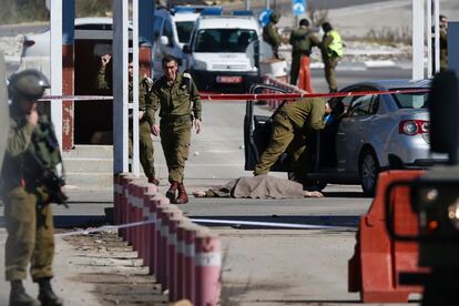 Soldados israel&iacute;es junto al cuerpo de un palestino que dispar&oacute; el pasado domingo en el paso militar Beit El, cerca de Ramala.