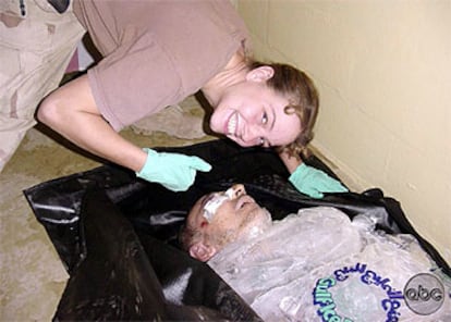 La soldado Sabrina Harman sonríe junto al cadáver de un iraquí.