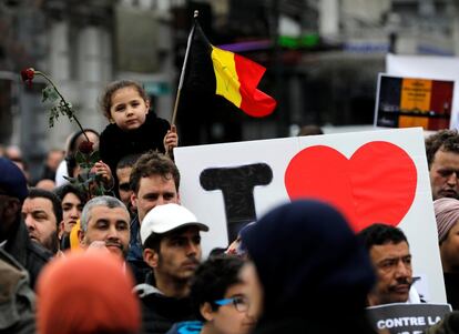 Una niña sostiene una bandera de Bélgica frente a la Bolsa para conmemorar a las víctimas del ataque terrorista.