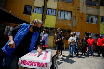 Una mujer deposita su voto durante la consulta de revocación de mandato de AMLO