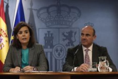 La vicepresidenta del Gobierno, Soraya S&aacute;ez de Santamar&iacute;a, y el ministro de Econom&iacute;a, Luis de Guindos, durante la rueda de prensa posterior al Consejo de ministros