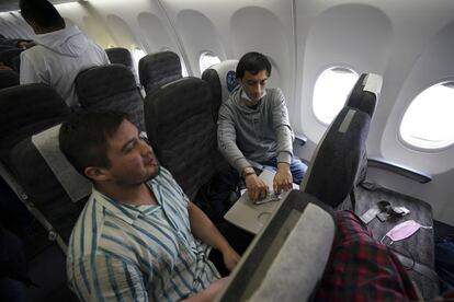 Los estudiantes de música Rodrigo Martínez y Yaroslav Labza juegan a las cartas en el vuelo de evacuación proporcionado por el Gobierno de México.