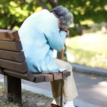 Senior woman sitting on park bench