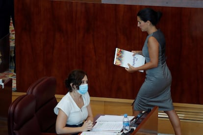 La portavoz de Vox, Rocío Monasterio, pasa ante la presidenta regional, Isabel Díaz Ayuso.