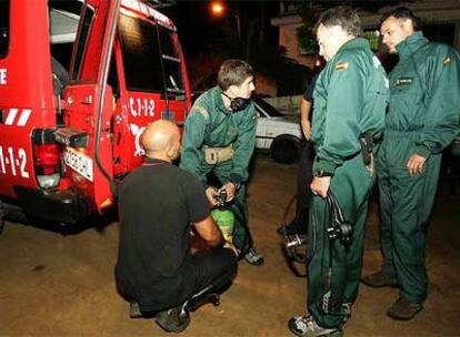 Miembros de la Guardia Civil, preparan sus equipos de buceo para iniciar el rescate de un grupo de jóvenes perdidos en el interior de una galería de agua en Tenerife