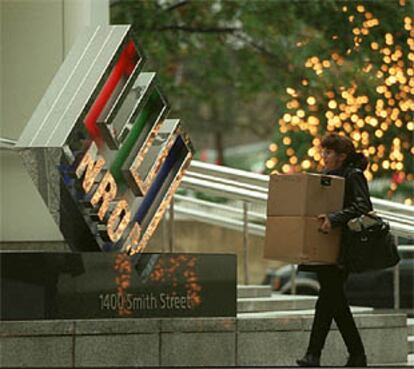 Una mujer llega anoche con unas cajas a las oficinas de Enron.