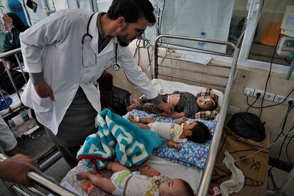 El doctor Mohammad Yaqob Sharafat pasa consulta en el hospital Indira Gandhi de Kabul, el mayor centro pediátrico de Afganistán, el 7 de agosto. En la sala en la que se tomó esta foto, hasta 18 niños acompañados de sus madres estaban repartidos en seis camas en poco más de 20 metros cuadrados. 