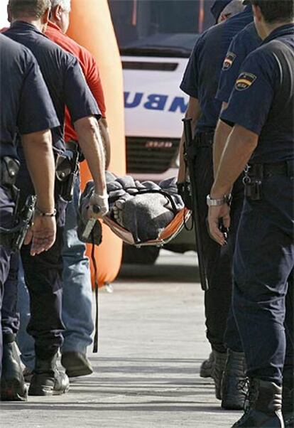 Un grupo de policías traslada el cadáver de un inmigrante llegado ayer en cayuco a Tenerife.