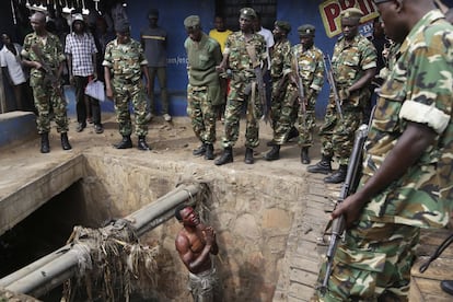 Jean Claude Niyonzima, un supuesto miembro de la milicia juvenil Imbonerakure, suplica a los soldados que lo protejan de una multitud de manifestantes en Bujumbura, Burundi.