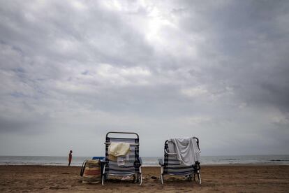 Dos hamacas solitarias bajo un cielo nublado en la playa de la Malvarrosa de Valencia, este jueves.