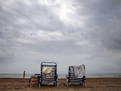 Dos hamacas solitarias bajo un cielo nublado en la playa de la Malvarrosa de Valencia, este jueves.
