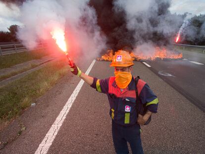 Un trabajador de la planta de Alcoa San Cibrao enciende una bengala durante una protesta ayer en la autovía A6 en Outeiro de Rei (Lugo).